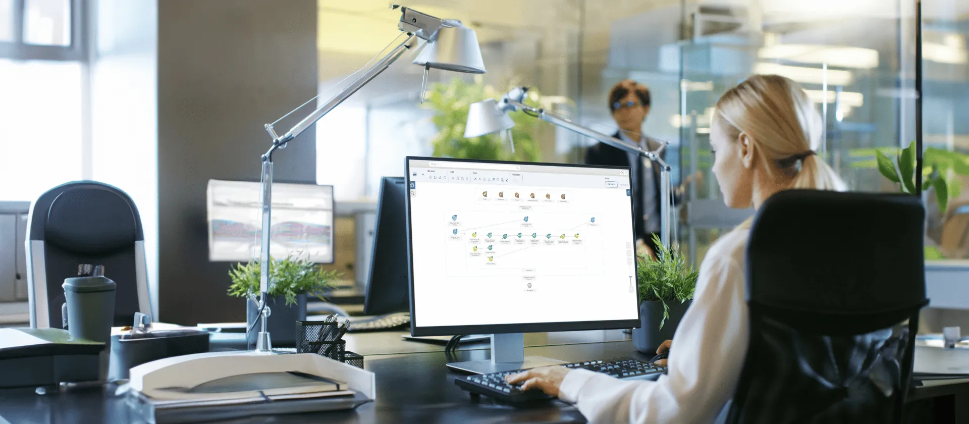 Businesswoman working on desktop computer with SAP analytics software in modern office environment
