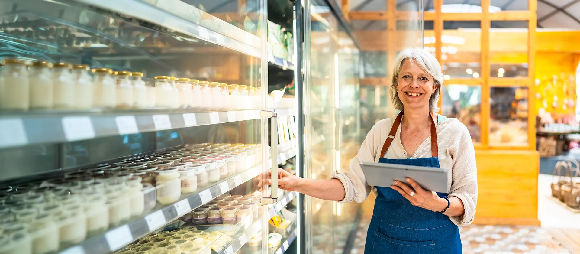 Person holding a tablet in a warehouse aisle while reviewing inventory for end‑to‑end supply chain planning with SAP IBP