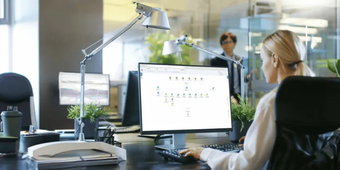 Businesswoman working on desktop computer with SAP analytics software in modern office environment