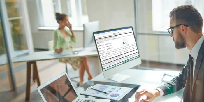 Businessman working on the computer managing BEPS 2.0 Pillar 2 reporting.