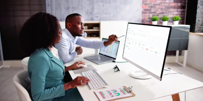 Two business professionals analyzing sustainability data from SAP sustainability control tower on a computer screen