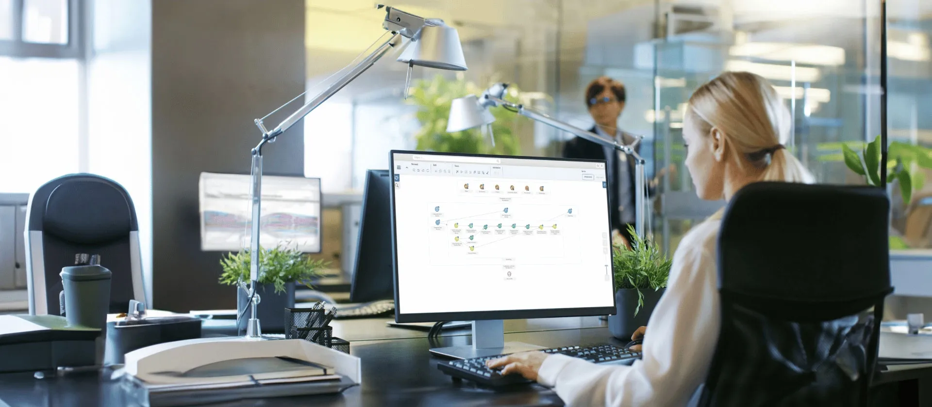 Businesswoman working on desktop computer with SAP analytics software in modern office environment